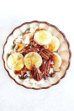 a bowl filled with bananas and pecans on top of a table