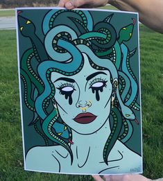 a person holding up a painting in the grass with an octopus on it's head