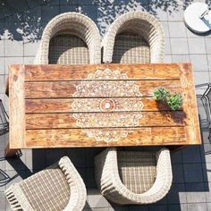 an overhead view of a wooden table with wicker chairs and potted plant on it