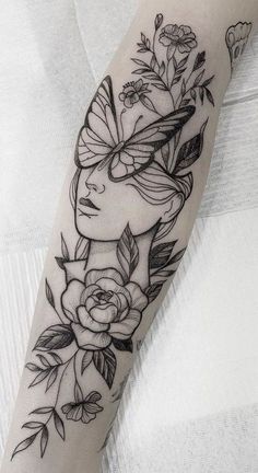 a woman's arm with flowers and butterflies on it, in black and white