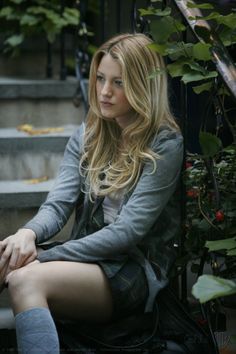 a woman sitting on the steps with her legs crossed