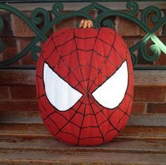 a spiderman pumpkin sitting on top of a bench