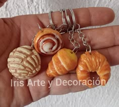 a person is holding three different types of food items in their palm tree keychain