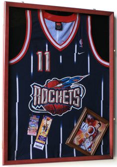 a basketball jersey with the name rockets on it is hanging in a wooden framed case