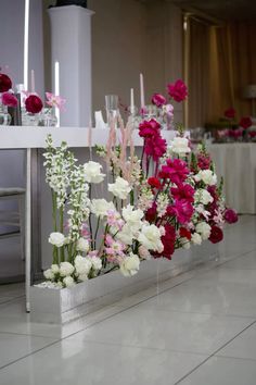 flowers and candles are arranged on the table for an elegant wedding reception in pink, white and red