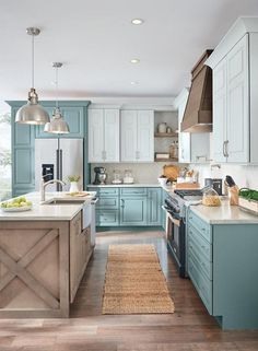 a large kitchen with blue cabinets and wooden flooring, along with a rug on the floor