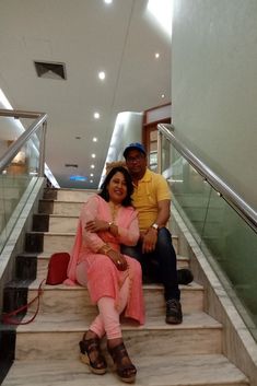 a man and woman sitting on some stairs