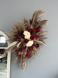 a dried flower arrangement hanging on the wall