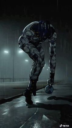 a man riding a skateboard on top of a wet road in the rain at night