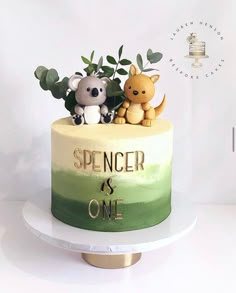 there is a cake decorated with two animals on top of it and the words spencer is one