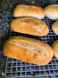 four loaves of bread cooling on a rack