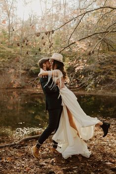 a man and woman are hugging in the woods