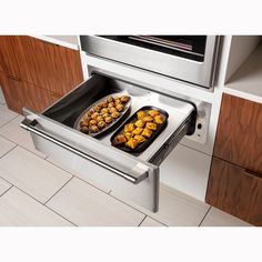 an oven with two trays of food in it