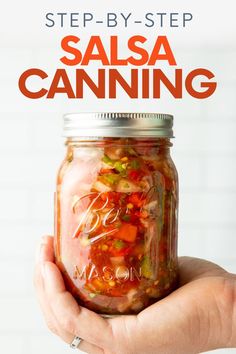 a hand holding a jar filled with salsa and the words, step - by - step salsa canning