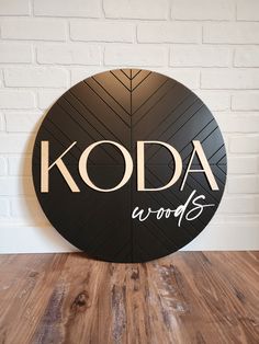 the koda words sign is on display in front of a white brick wall and wooden floor