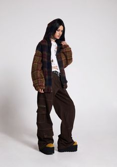 This fully lined jacket has a sherpa construction with a plaid design, side pockets, nylon strap detailing on the shoulders, o-ring hardware, an attached hood, and a front zipper closure. Plaid Outerwear With Pockets For Streetwear, Winter Plaid Streetwear Outerwear, Winter Plaid Outerwear For Streetwear, Hooded Grunge Outerwear With Pockets, Urban Plaid Outerwear For Streetwear, Current Mood Clothing, Fur Costume, Clown Costume, Group Costumes