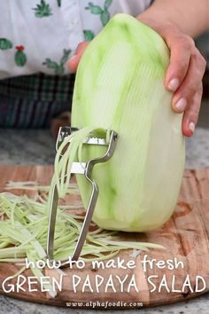 someone is grating green papaya salad on a cutting board with the words how to make fresh green papaya salad