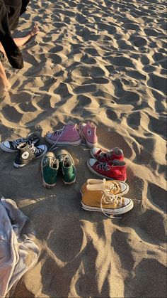 several pairs of shoes are sitting in the sand