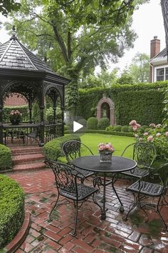 a gazebo in the middle of a lush green garden