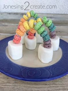 marshmallows are arranged in the shape of a rainbow caterpillar on a blue plate