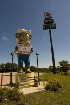 a large statue of a man holding a welcome sign