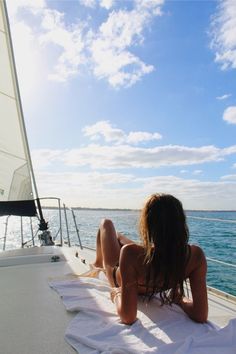 a woman laying on the back of a boat