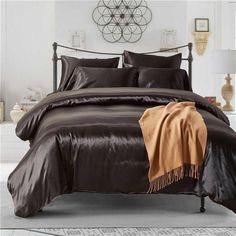 a bed with brown sheets and pillows on it