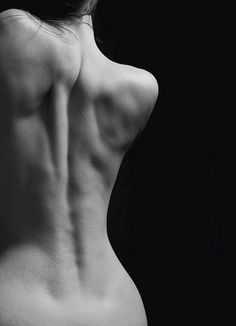 the back of a woman's body with her hands on her hips and one arm behind her head