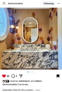 the bathroom is decorated with pink and gold accents, including an oval mirror above the marble sink