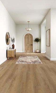 an empty room with wood floors and white walls