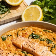 two pieces of salmon are in a bowl of pasta