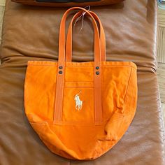 Signature Canvas Tote Bag By Polo Ralph Lauren. Summer Orange Color ! Zipper For Security! Pocket Inside. Medium Size 15x18”. Hands Drop 9”. New, No Tags . Embroidery. Bag Has A Stain . Ralph Lauren Summer, Ralph Lauren Tote, Ralph Lauren Handbags, Summer Orange, Plaid Tote, Denim Handbags, Ralph Lauren Bags, Blue Tote Bag, Suede Tote