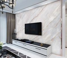 a living room with white marble walls and black furniture, along with a flat screen tv mounted on the wall