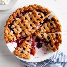 a pie on a white plate with blue and white striped napkins next to it