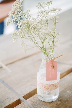 a vase filled with baby's breath sitting on top of a wooden table