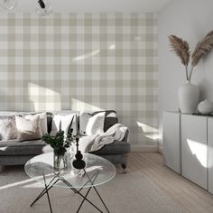 a living room with couches, tables and vases on the floor in front of a checkered wall