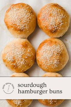 four hamburger buns with sesame seeds on top and the words, sourdough hamburger buns