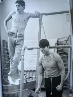 an old photo of two men standing on a boat, one is holding onto the railing