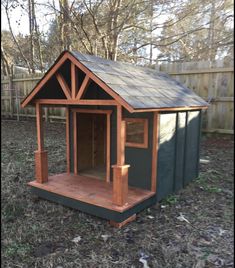 a small dog house in the yard with wood trimmings and shingled roof