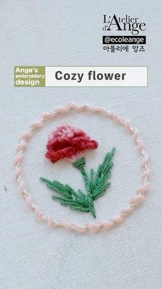 an embroidered piece with a flower on it in the shape of a circle and text that reads, cozy flower