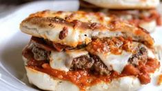 two meatball sandwiches are stacked on top of each other with tomato sauce and mozzarella