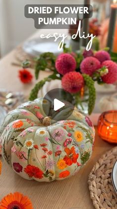 a table topped with flowers and pumpkins on top of it's wooden table