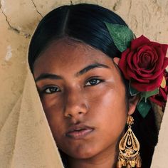 an image of a woman with a rose in her hair and earrings on her head