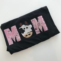 a black bag with a cow on it and the word mom written in large letters