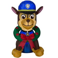 a small toy dog wearing a blue hat and green shirt with a red bow around its neck