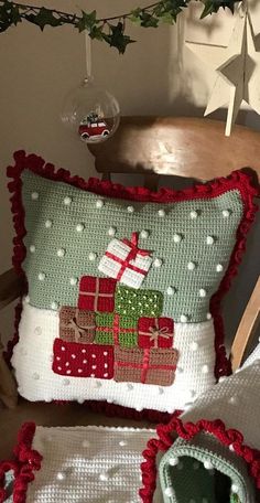 a christmas pillow on a chair next to a potted plant and glass ornament