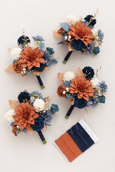 three bridal bouquets with blue, orange and white flowers