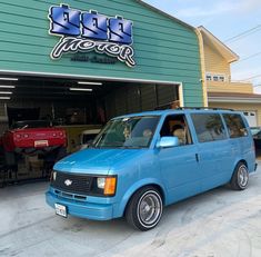 a blue van parked in front of a garage