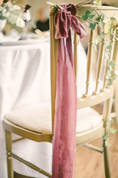 a chair with a pink scarf tied to it's back on top of a table