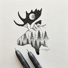 two pens sitting on top of a piece of paper next to a drawing of a moose